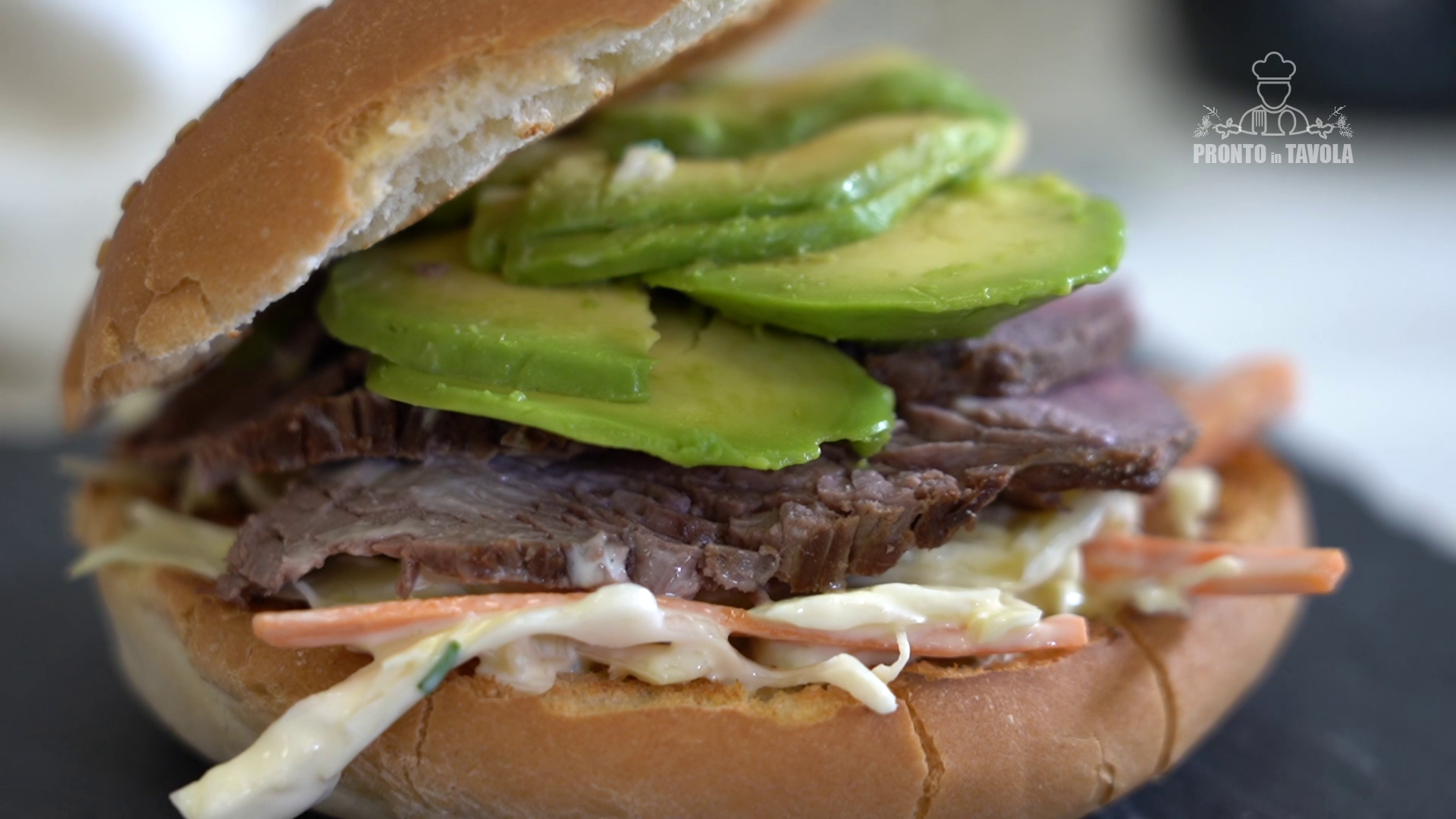 Panino al sesamo con roast-beef, avocado e insalata coleslaw